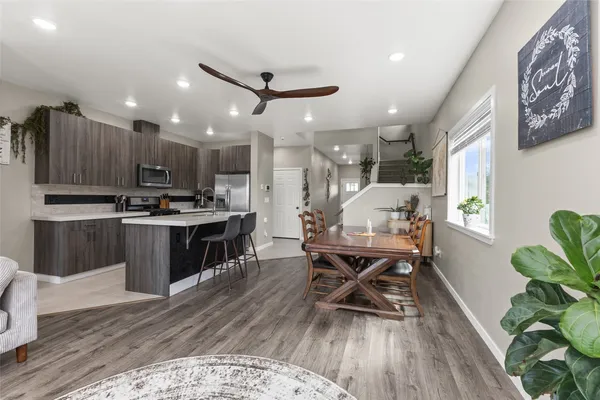 a kitchen with stainless steel appliances kitchen island granite countertop lots of wooden furniture a refrigerator a sink and a stove