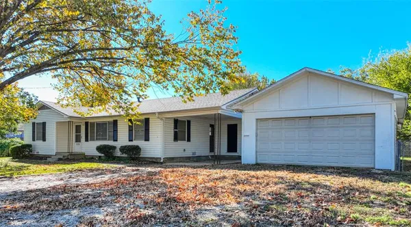 a front view of house with yard and trees around