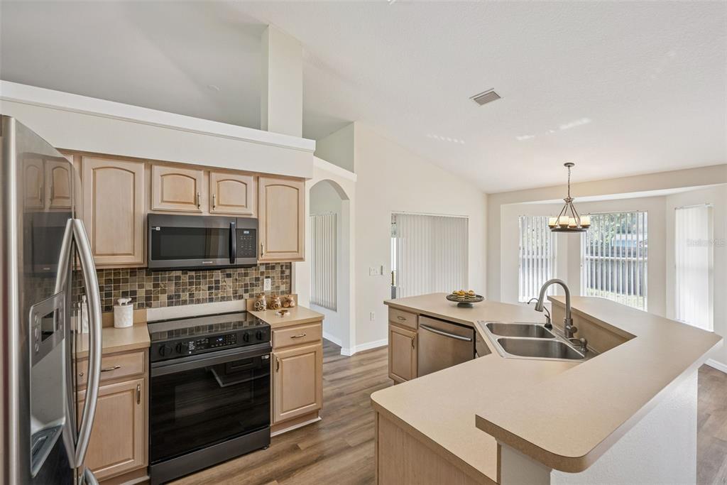893 Watt Circle Deltona, FL 32738 - Photo 12 of 34 a kitchen with a stove a sink and a refrigerator