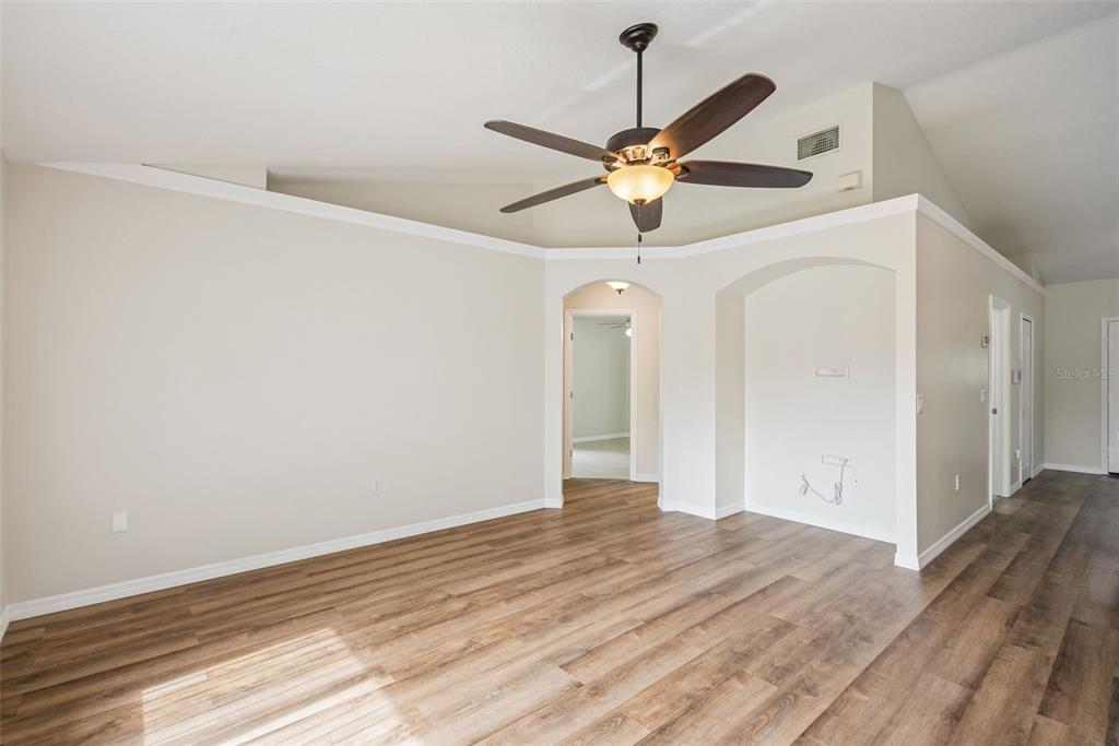 893 Watt Circle Deltona, FL 32738 - Photo 14 of 34 an empty room with wooden floor fan and windows