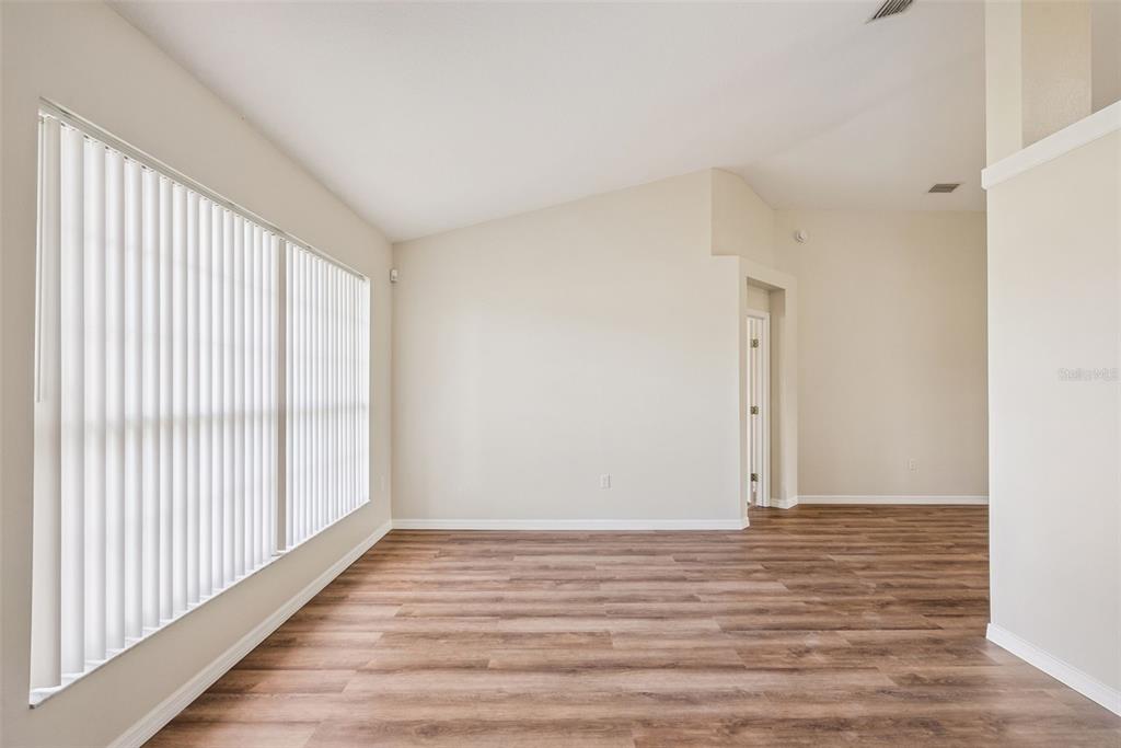 893 Watt Circle Deltona, FL 32738 - Photo 4 of 34 a view of an empty room with wooden floor and a window