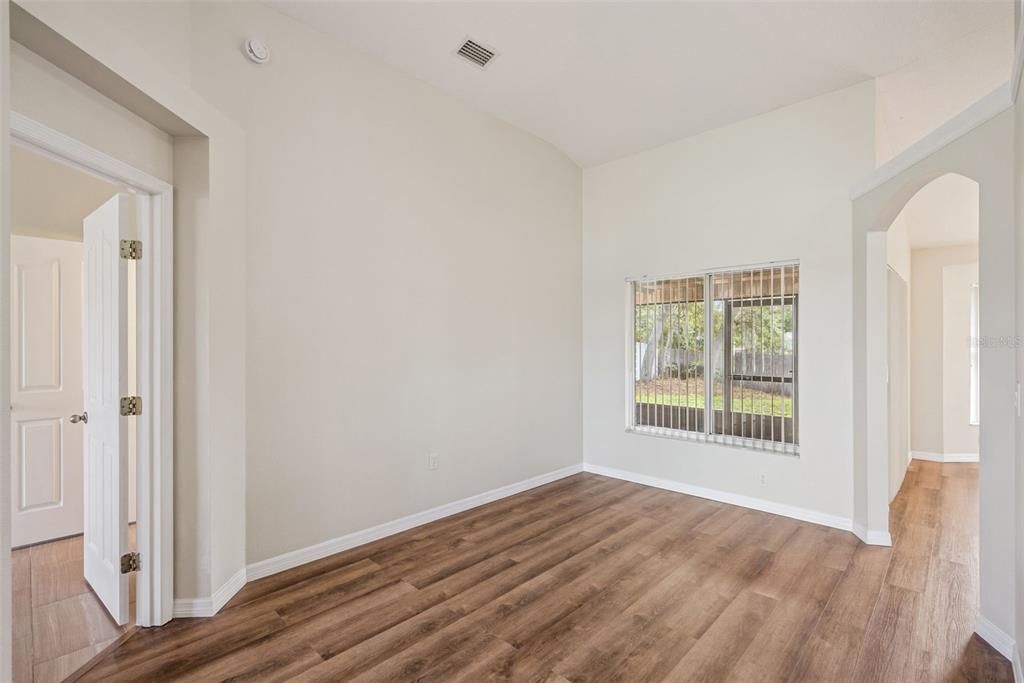 893 Watt Circle Deltona, FL 32738 - Photo 7 of 34 an empty room with wooden floor and windows