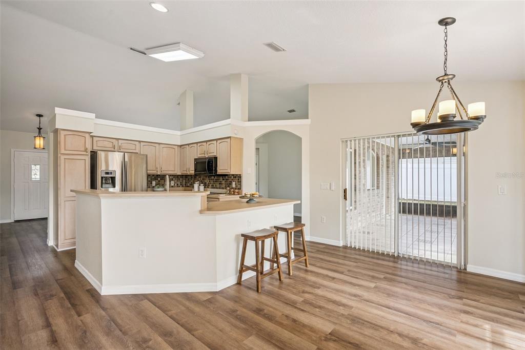 893 Watt Circle Deltona, FL 32738 - Photo 10 of 34 a kitchen with stainless steel appliances granite countertop a refrigerator a stove a sink dishwasher and white cabinets with wooden floor