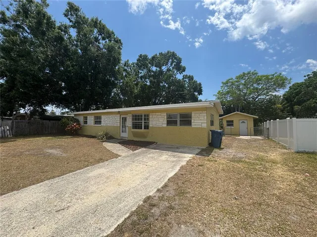 a front view of a house with a yard and trees