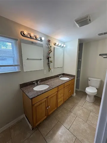 a bathroom with a sink a toilet and mirror