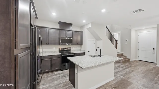 a kitchen with stainless steel appliances granite countertop a sink refrigerator and microwave