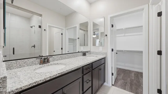 a bathroom with a granite countertop shower sink and mirror