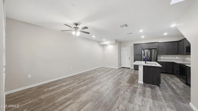a kitchen that has a sink a refrigerator a microwave and cabinets