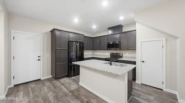 a kitchen with stainless steel appliances granite countertop a sink refrigerator and microwave