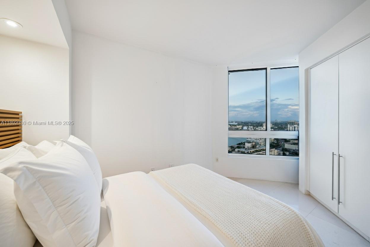 6365 Collins Avenue, Unit 2901 Miami Beach, FL 33141 - Photo 19 of 44 a bedroom with a bed and a window