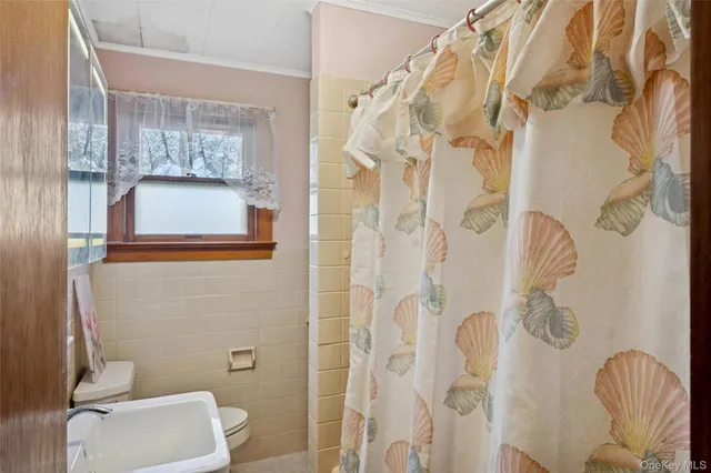 a white toilet sitting next to a bathroom