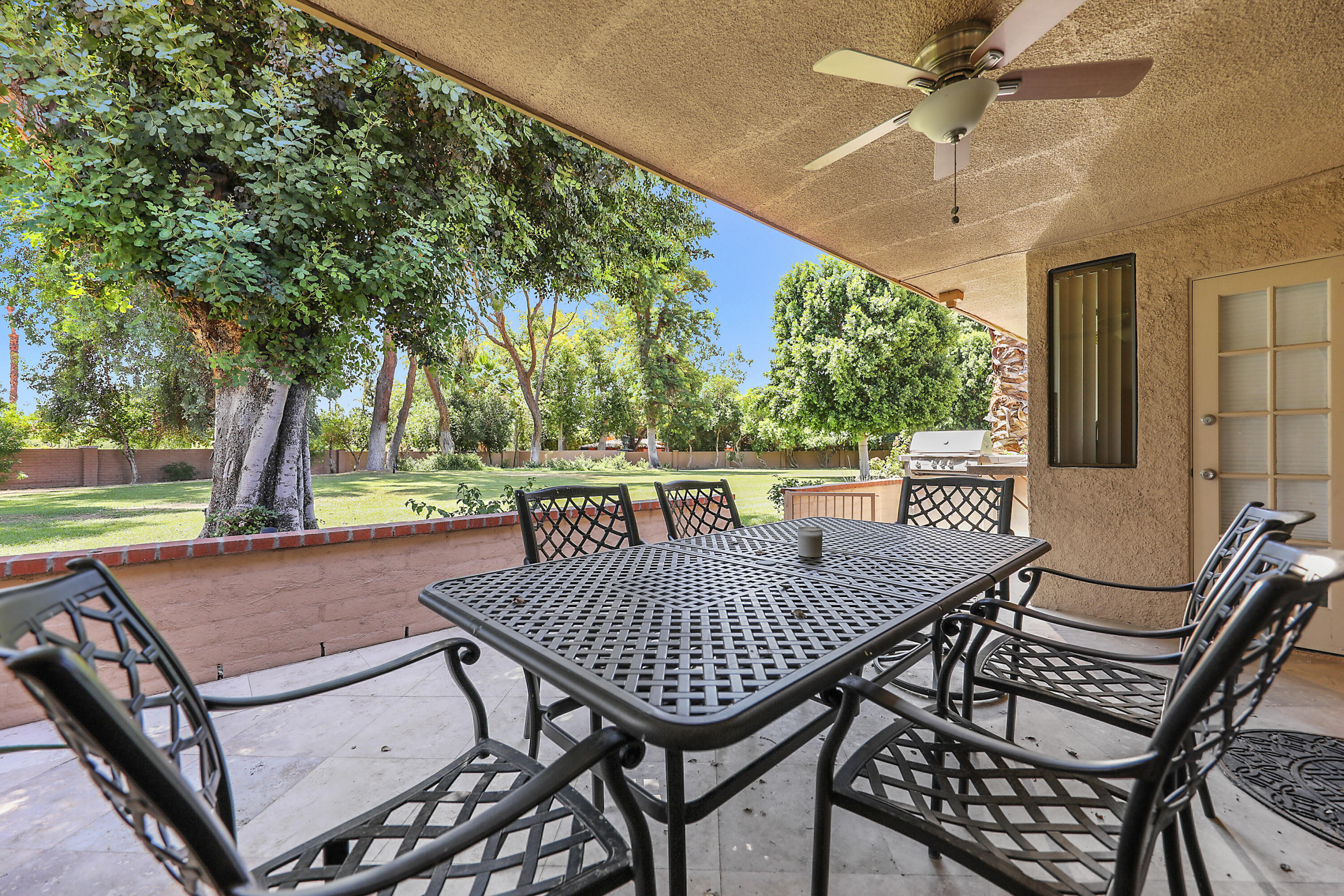 5 Majorca Drive Rancho Mirage, CA 92270 - Photo 19 of 40 a view of a patio with table and chairs and a barbeque with wooden floor and fence