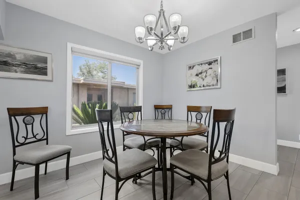a view of a dining room with furniture a chandelier and wooden floor