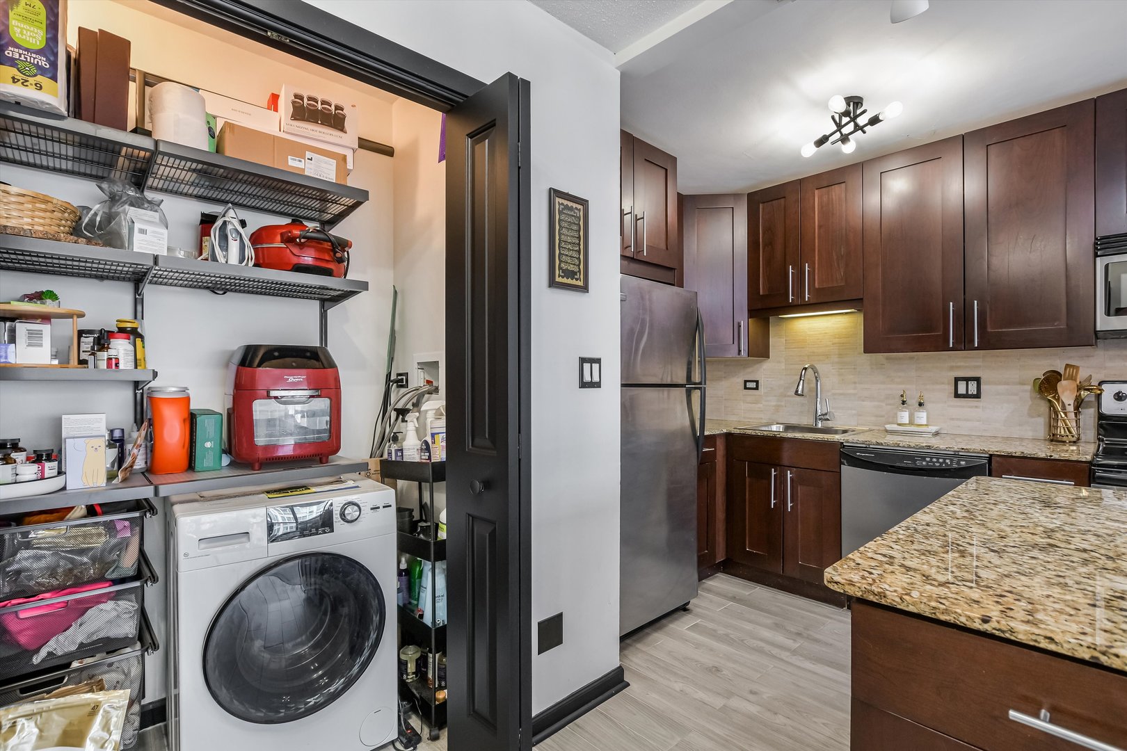 2930 North Sheridan Road, Unit 1111 Chicago, IL 60657 - Photo 14 of 28 a kitchen with stainless steel appliances granite countertop cabinets and washer
