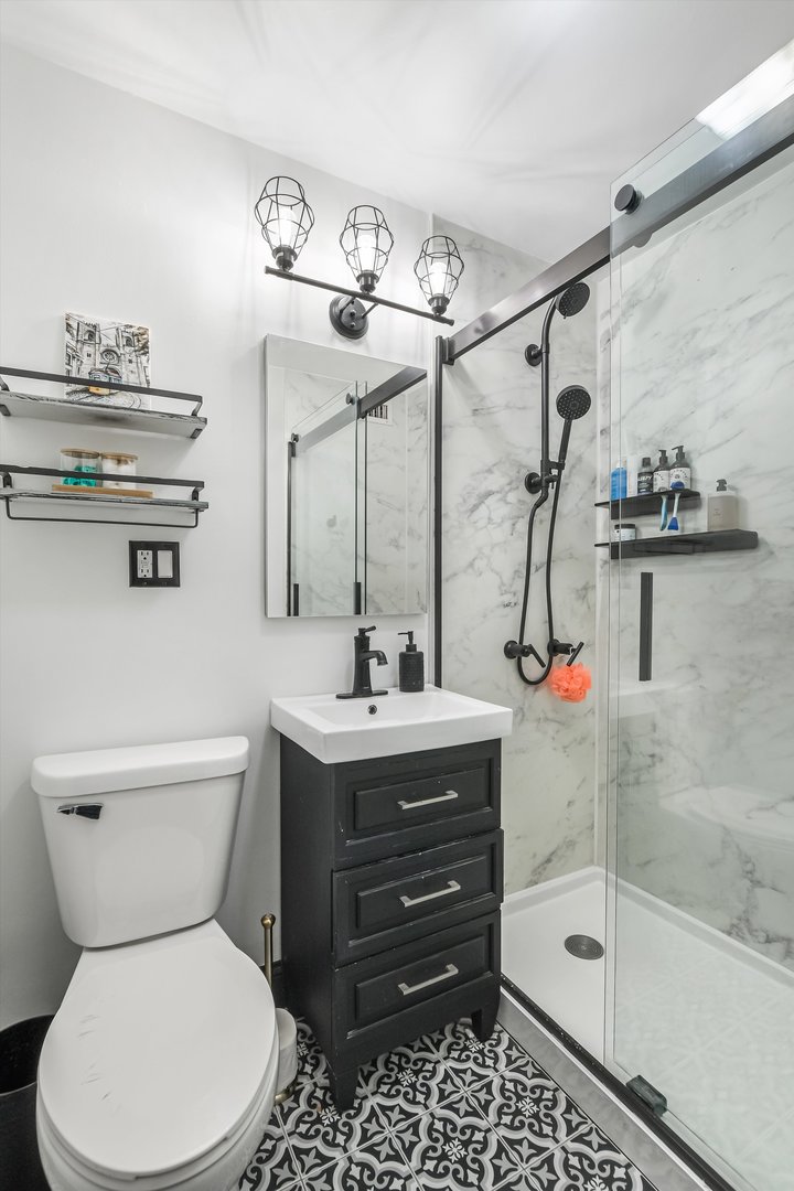 2930 North Sheridan Road, Unit 1111 Chicago, IL 60657 - Photo 15 of 28 a bathroom with a toilet sink and mirror