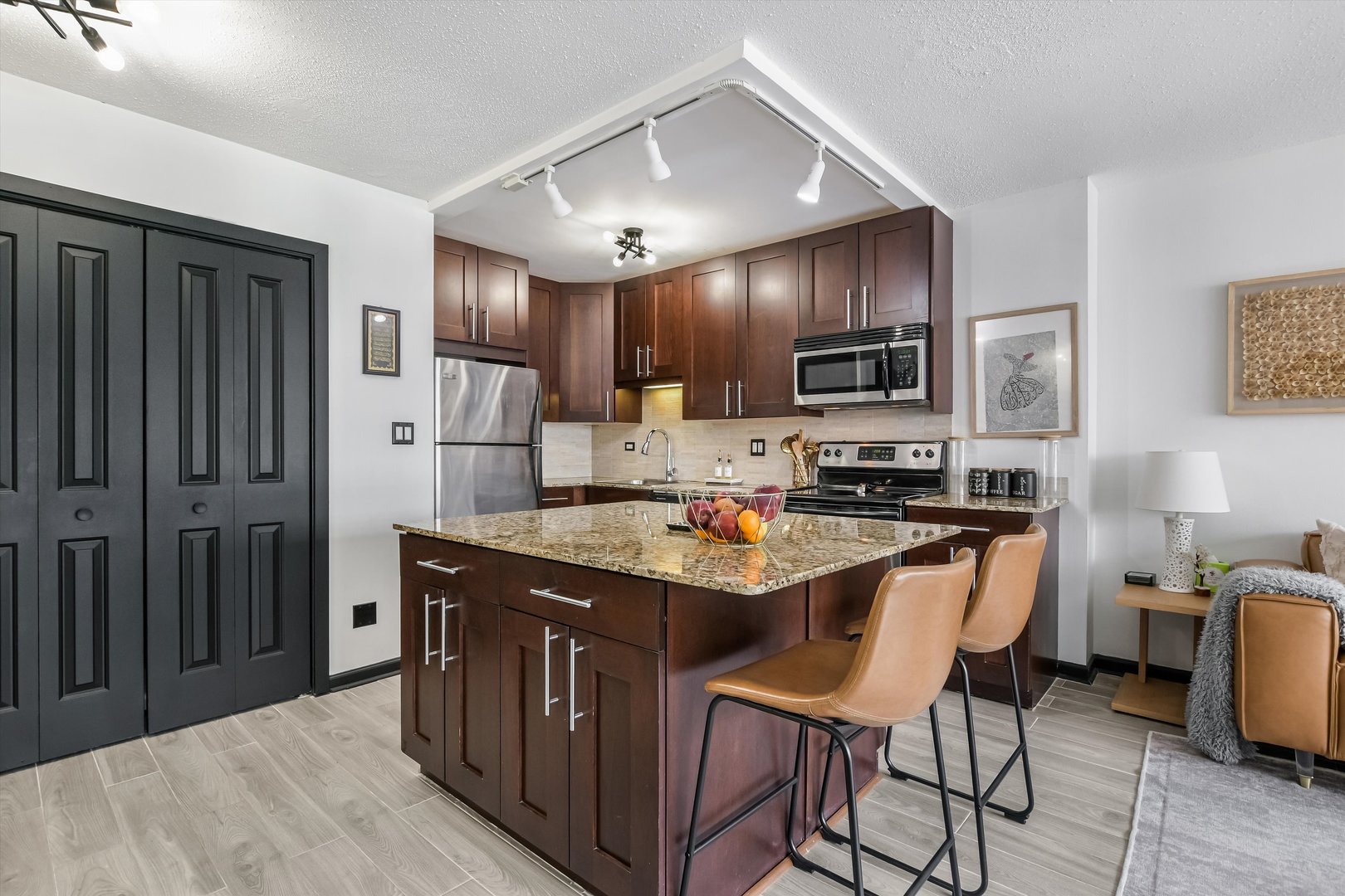 2930 North Sheridan Road, Unit 1111 Chicago, IL 60657 - Photo 3 of 28 a kitchen with kitchen island granite countertop a sink stove and refrigerator