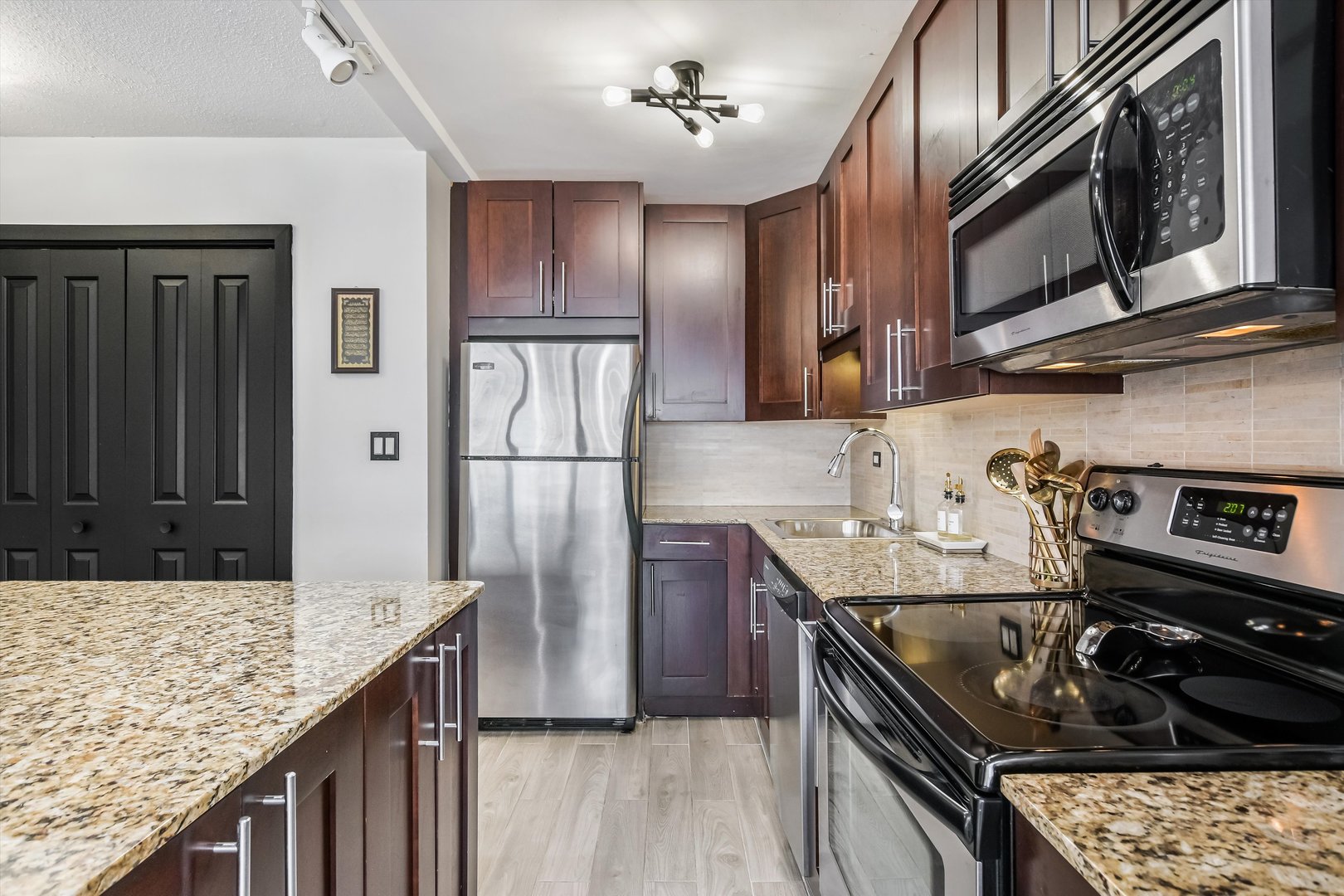 2930 North Sheridan Road, Unit 1111 Chicago, IL 60657 - Photo 4 of 28 a kitchen with stainless steel appliances granite countertop a sink stove and refrigerator