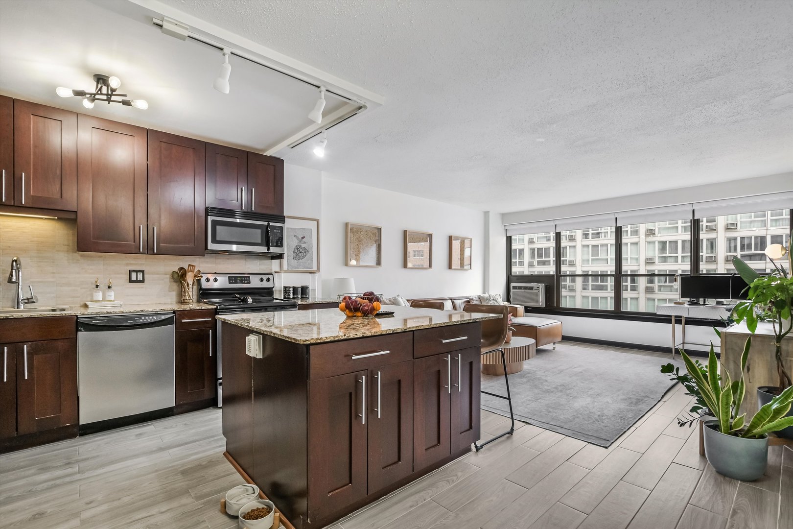 2930 North Sheridan Road, Unit 1111 Chicago, IL 60657 - Photo 5 of 28 a kitchen with stainless steel appliances granite countertop a stove top oven a sink dishwasher a dining table and chairs with wooden floor