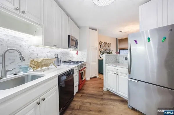 a kitchen with stainless steel appliances granite countertop a sink stove and cabinets