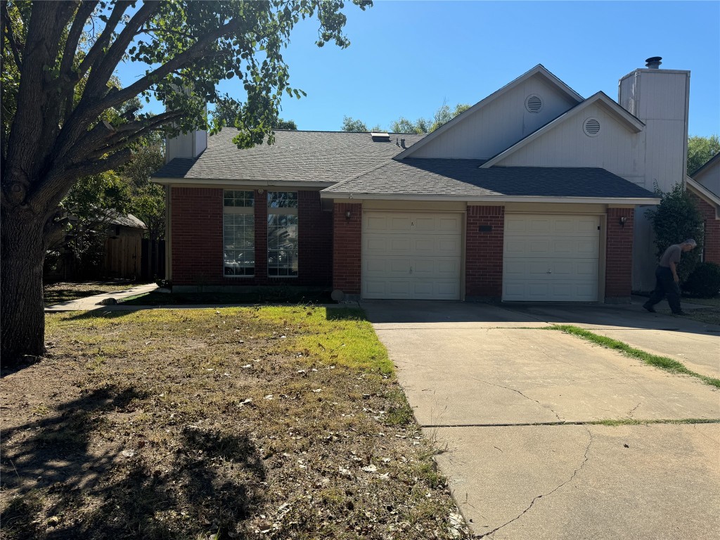 12309 Turtle Rock Road, Unit A Austin, TX 78729 - Photo 1 of 14 a front view of a house with a yard and garage