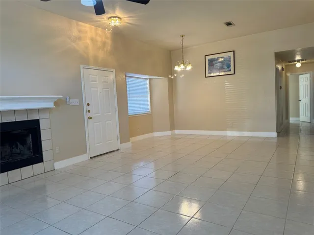 an empty room with windows and fireplace