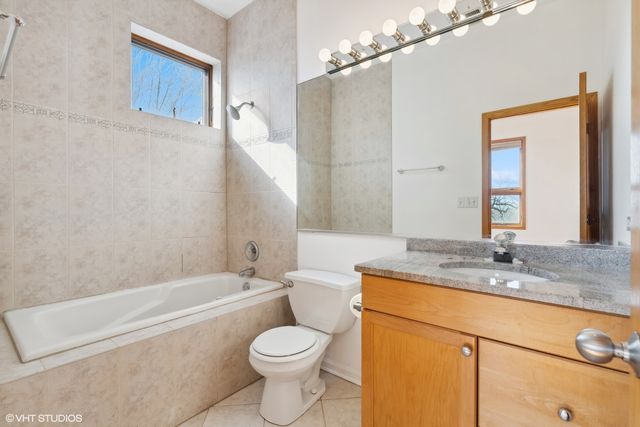 a bathroom with a granite countertop toilet sink and mirror
