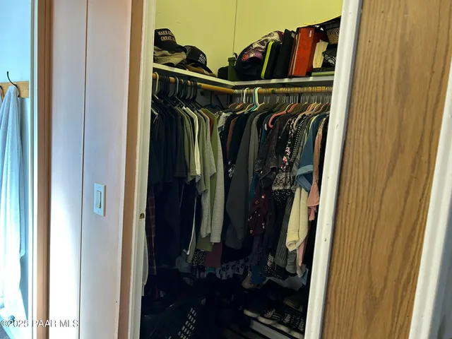 a view of walk in closet with clothes and shoes
