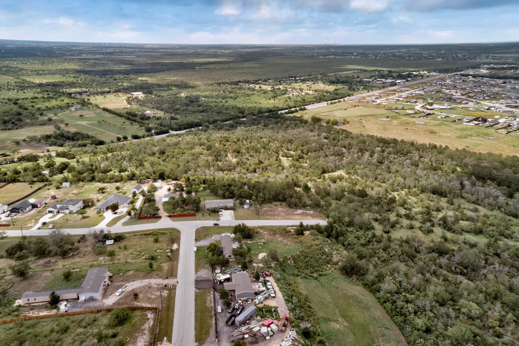 693 Santa Teresa Road Kyle, TX 78640 - Photo 8 of 20 An aerial perspective reveals a vast expanse of verdant landscapes, offering potential for development.