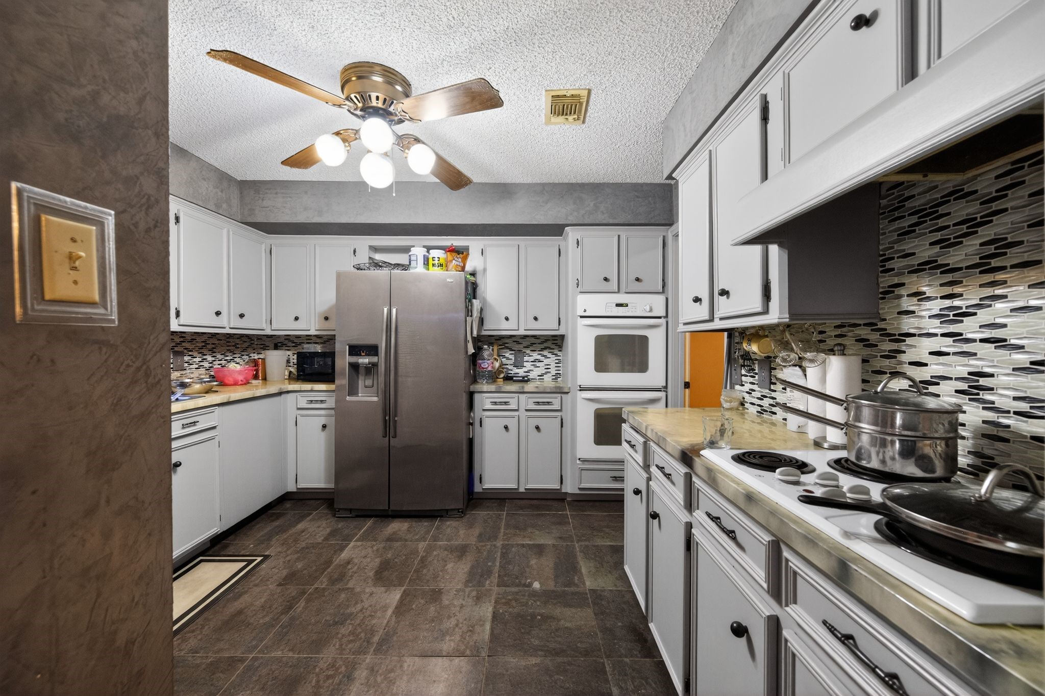 7815 Hummingbird Street Houston, TX 77071 - Photo 11 of 24 a kitchen with a refrigerator a stove top oven a sink and dishwasher