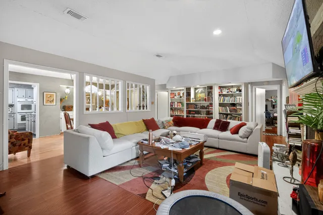 a dining room with furniture potted plants and wooden floor