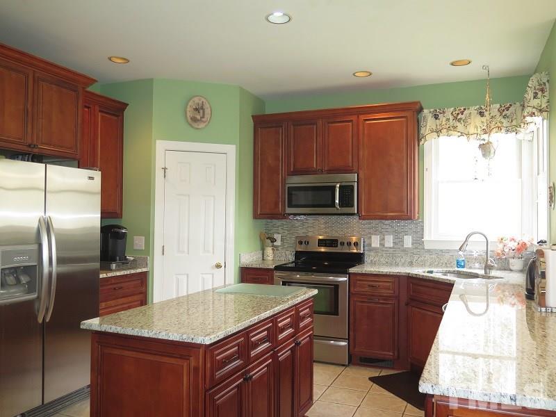 11316 John Allen Road Raleigh, NC 27614 - Photo 5 of 25 a kitchen with kitchen island granite countertop a sink stove and refrigerator