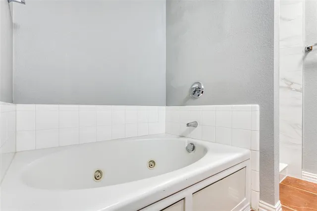 a bathroom with a tub and toilet