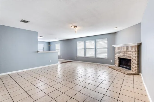 a view of empty room with wooden floor and fireplace