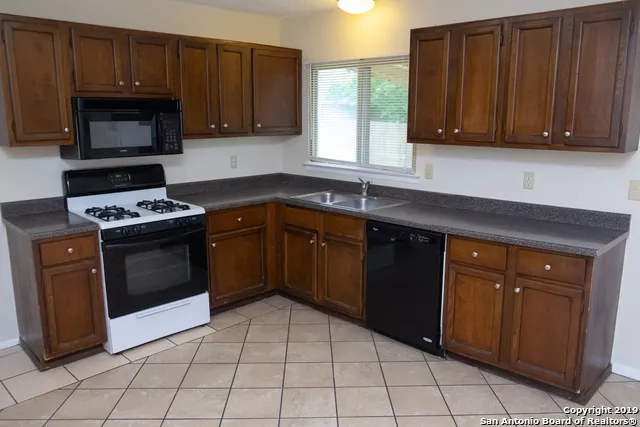 a kitchen with a sink a stove and cabinets