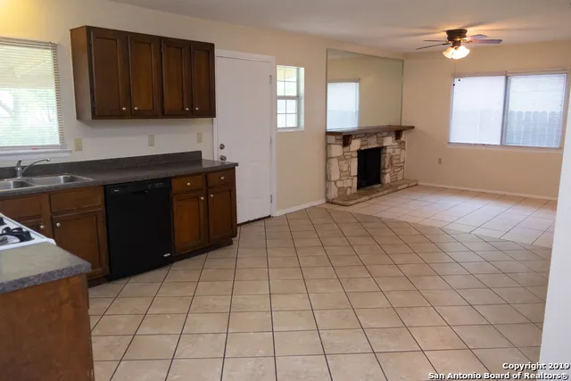 a kitchen with granite countertop a stove a sink and a microwave