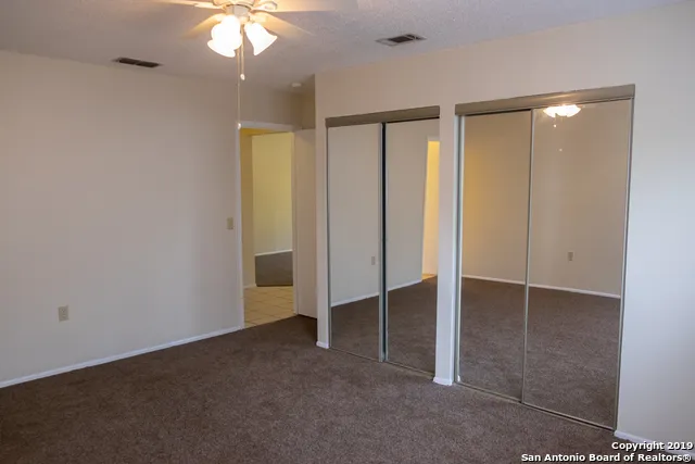 an empty room with windows and closet