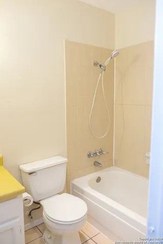 a white toilet and tub sitting next to a bathroom sink