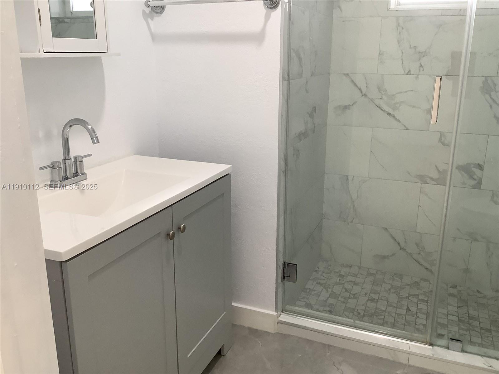 7435 Southwest 23rd Street, Unit FRONT Miami, FL 33155 - Photo 11 of 28 a bathroom with a sink and shower