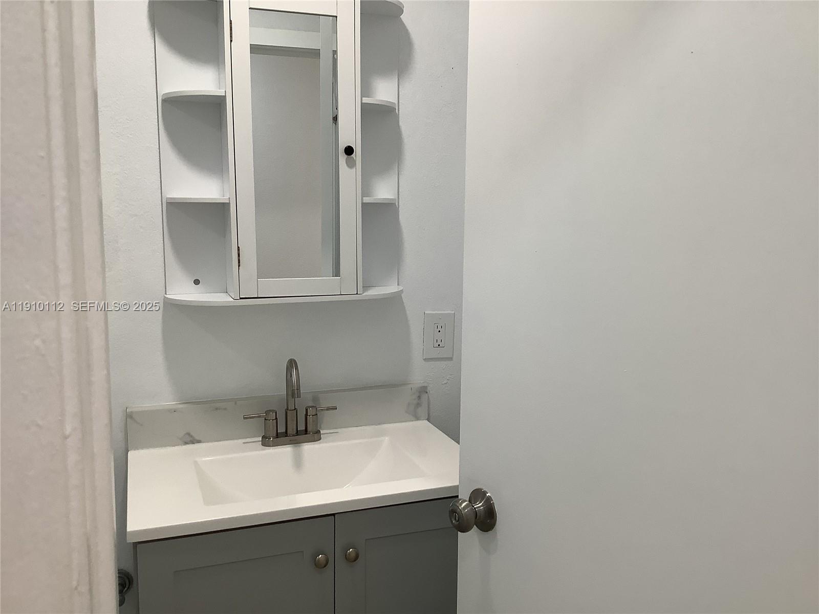 7435 Southwest 23rd Street, Unit FRONT Miami, FL 33155 - Photo 23 of 28 a bathroom with a sink and mirror