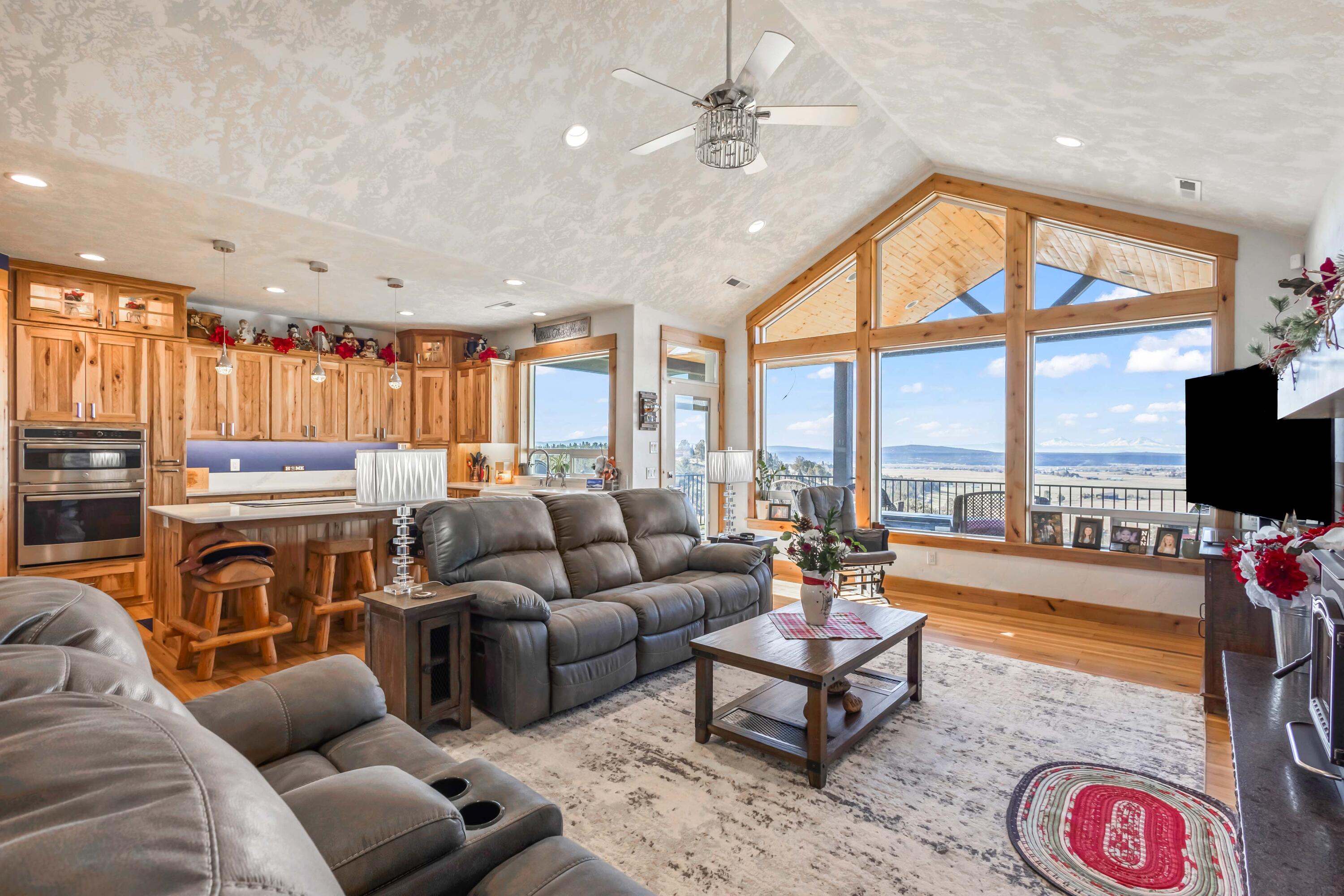 5582 North Mckay Road Prineville, OR 97754 - Photo 9 of 54 a living room with furniture a flat screen tv and a floor to ceiling window