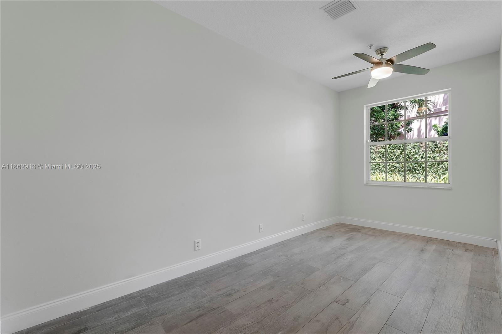 108 Lighthouse Circle, Unit E Tequesta, FL 33469 - Photo 12 of 34 wooden floor in an empty room with a window