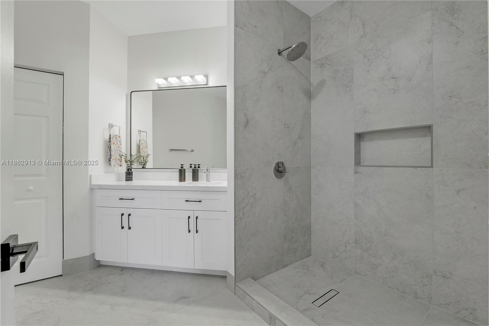 108 Lighthouse Circle, Unit E Tequesta, FL 33469 - Photo 19 of 34 a bathroom with a double vanity sink mirror and shower