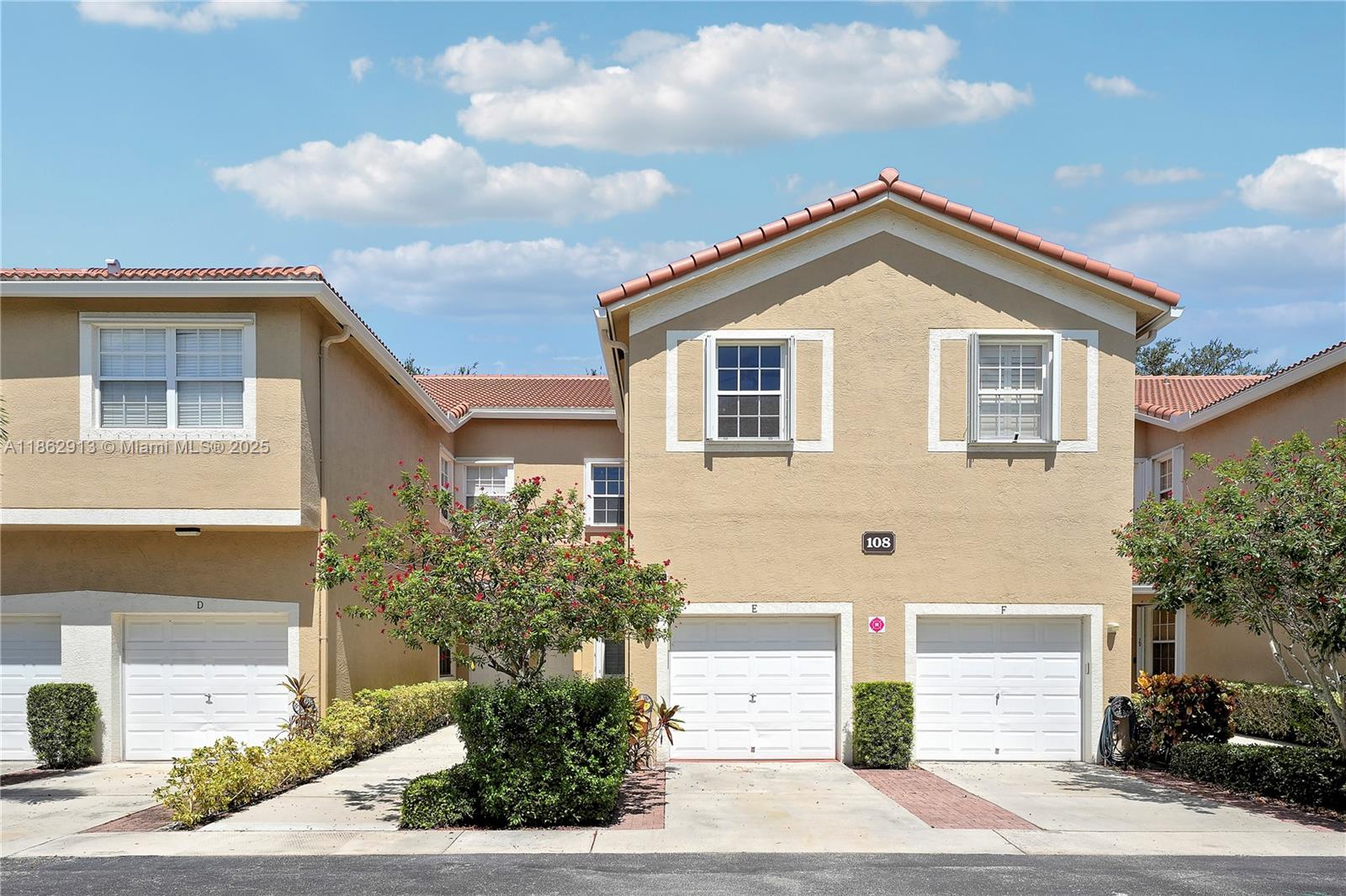 108 Lighthouse Circle, Unit E Tequesta, FL 33469 - Photo 2 of 34 a front view of a house with a yard and garage