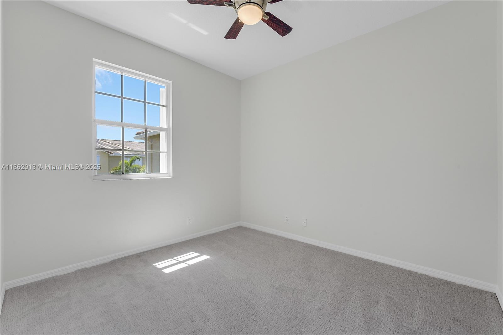 108 Lighthouse Circle, Unit E Tequesta, FL 33469 - Photo 21 of 34 an empty room with a ceiling fan and window