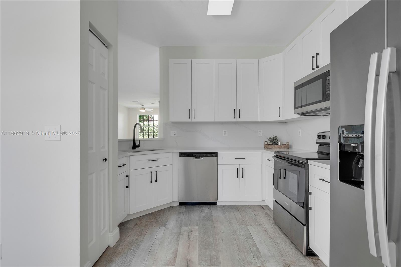 108 Lighthouse Circle, Unit E Tequesta, FL 33469 - Photo 4 of 34 a kitchen with cabinets and stainless steel appliances