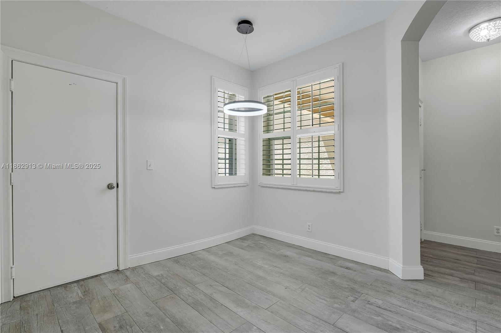 108 Lighthouse Circle, Unit E Tequesta, FL 33469 - Photo 7 of 34 an empty room with wooden floor and windows