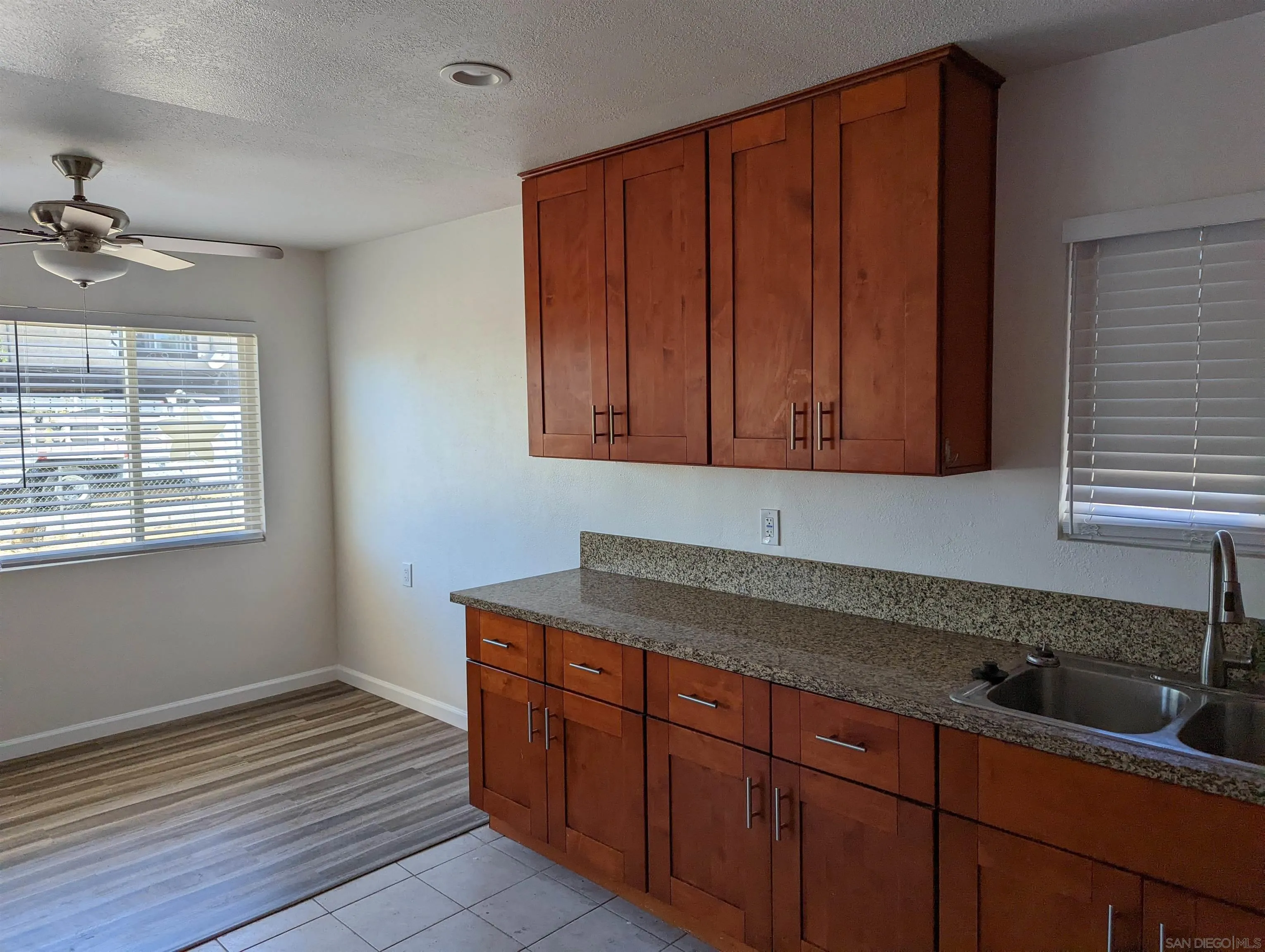 1207-9 Lyons Lane El Cajon, CA 92021 - Photo 10 of 39 a kitchen with granite countertop wooden cabinets a sink and dishwasher