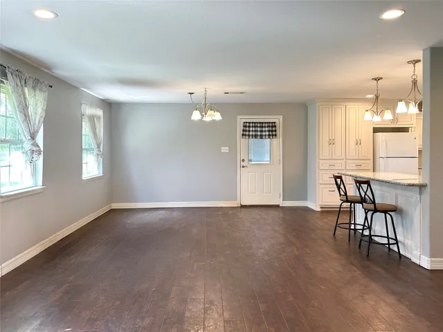 an empty room with windows and wooden floor
