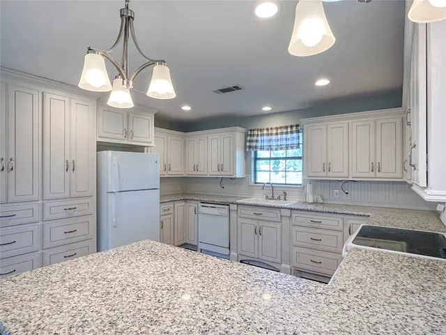 a kitchen with a refrigerator a sink and cabinets