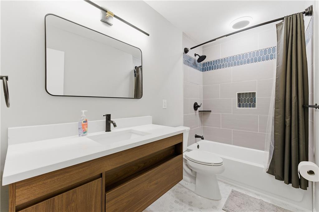 1063 Seville Drive Clarkston, GA 30021 - Photo 12 of 25 a bathroom with a sink toilet and shower